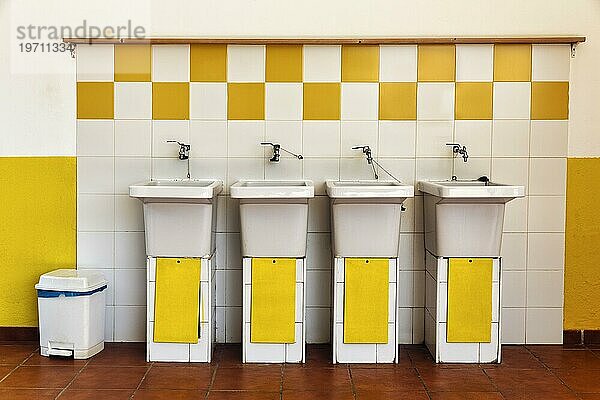 Vier alte Waschbecken nebeneinander  gelb und weiß  Waschraum  sanitäre Anlage auf einem Campingplatz  Innenaufnahme  Spanien  Europa