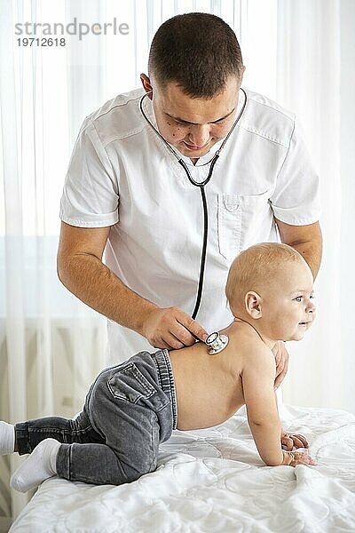 Arzt hört süßes kleines Baby mit Stethoskop ab