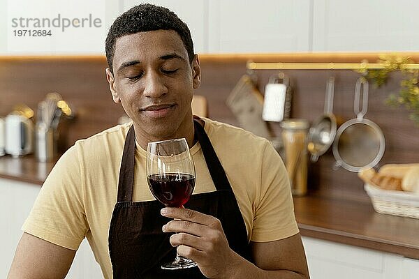 Porträt Mann zu Hause trinkt Wein