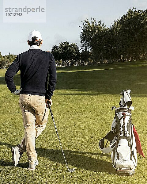 Mann mit Golfschlägerfeld