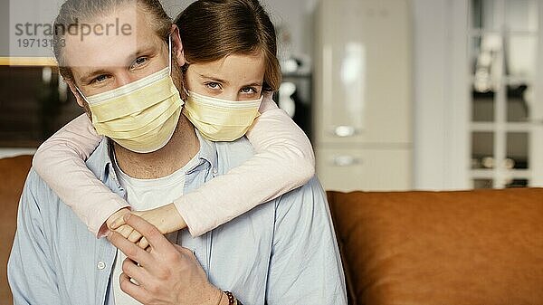 Vorderansicht kleines Mädchen  das Zeit mit seinem Vater verbringt und eine medizinische Maske trägt