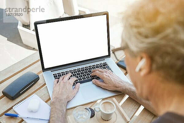Close up Senior Mann tippen Laptop mit weißen leeren Bildschirm