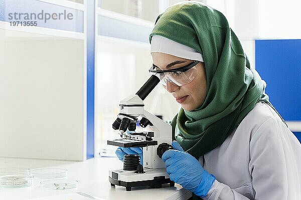 Seitenansicht Wissenschaftlerin mit Hidschab Mikroskop