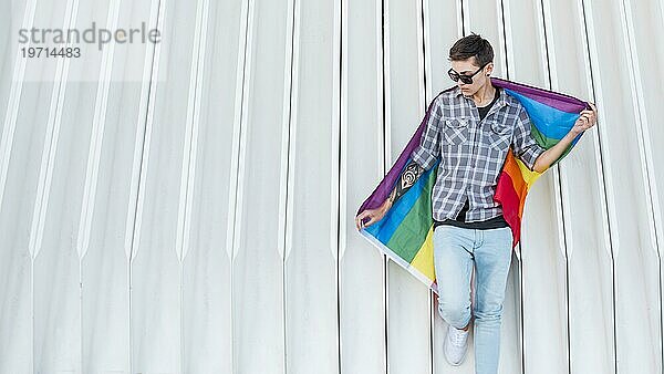 Junger Transgender hält LGBT Flagge