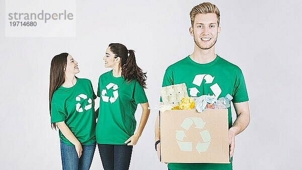 Lächelnde Frauen glücklicher Mann hält Karton mit recycelten Gegenständen