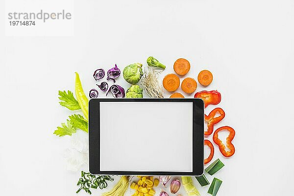 Erhöhte Ansicht digitale Tablette gehackt Gemüse weißem Hintergrund