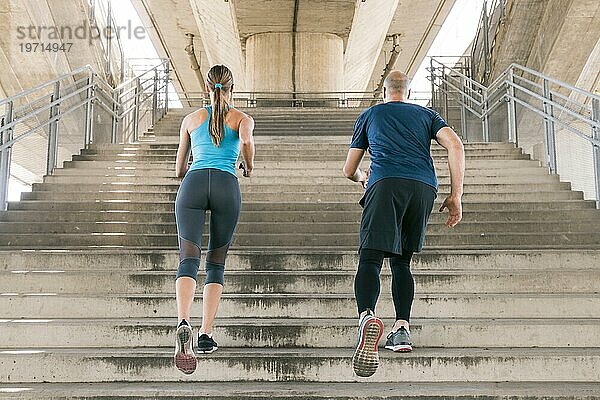 Rückansicht männlicher weiblicher Athlet joggend Treppenhaus