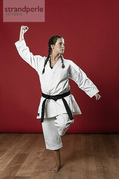 Frau in Kampfsportuniform bei der Ausübung von Karate