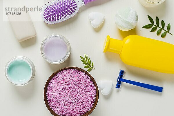 Draufsicht auf rosa Salz mit Kosmetikprodukten weißer Hintergrund