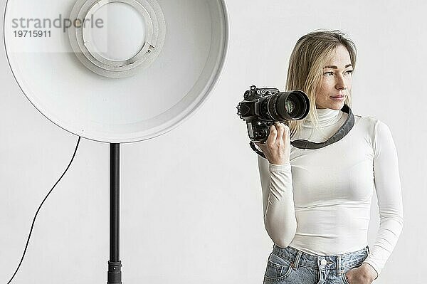 Frau hält Kamera Studiolampe