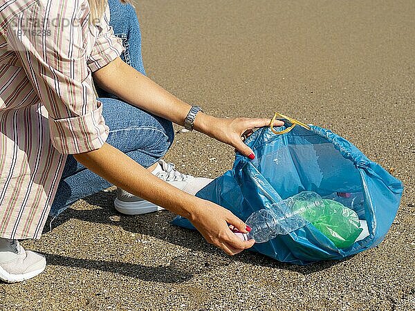 Frau sammelt Plastikflaschenbeutel