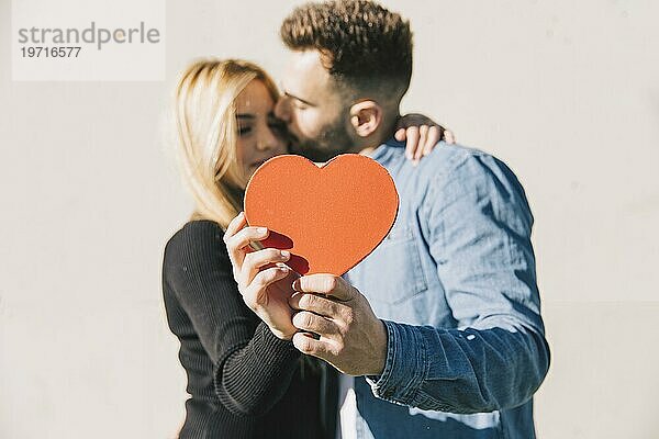 Verliebtes Paar posiert mit rotem Herz