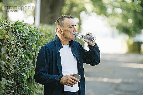 Alter Mann trinkt Wasserpark