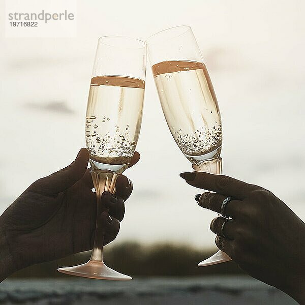 Frauen halten Champagnergläser Hintergrund Sonnenuntergang