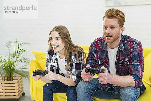 Junges Paar hat Spaß beim Spielen eines Videospiels zu Hause