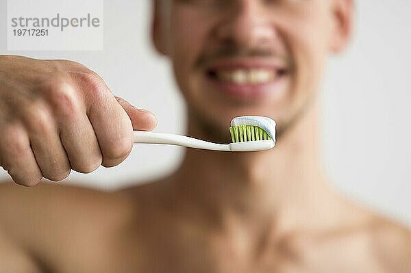 Vorderansicht defokussiert Mann hält Zahnbürste mit Zahnpasta es