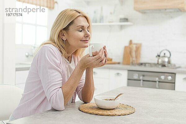 Schöne ältere Frau genießt das Frühstück