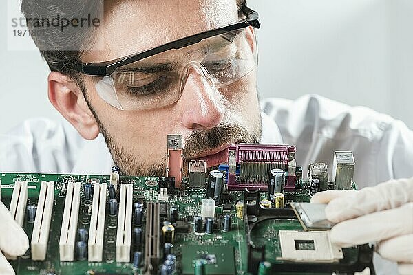 Männlicher Techniker beim Einsetzen eines Chip Computer Motherboards