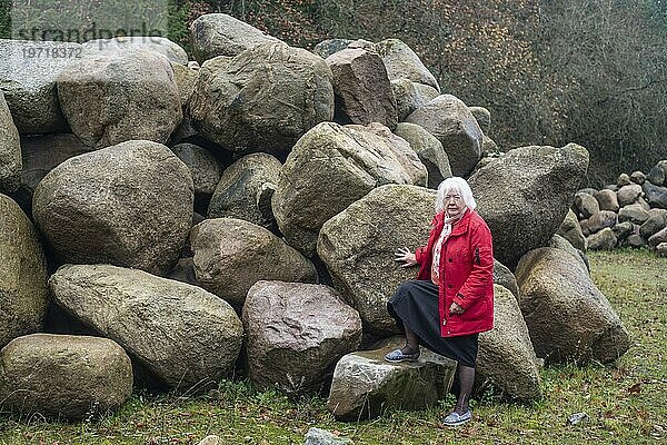 Frau steht an einem Steinlager in der Natur in Fyledalen  Gemeinde Tomelilla  Schonen  Schweden  Skandinavien  Europa
