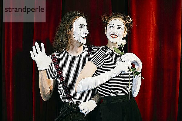 Porträt zwei glückliche Pantomimen vor rotem Vorhang