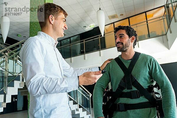 Mechanisches Exoskelett  Physiotherapeut im Gespräch mit einer behinderten Person mit Roboterskelett  Physiotherapie in einem modernen Krankenhaus  futuristische Physiotherapie