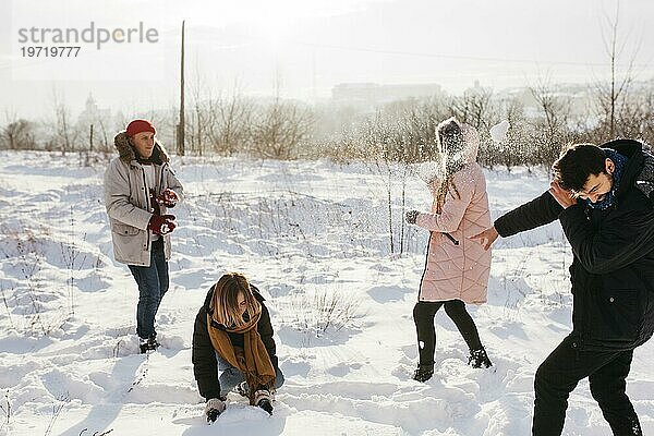 Menschen spielen Schneebälle Winterwald