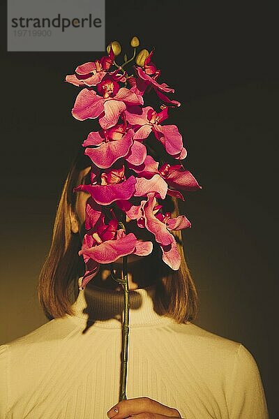 Frau bedeckt Gesicht mit Blume