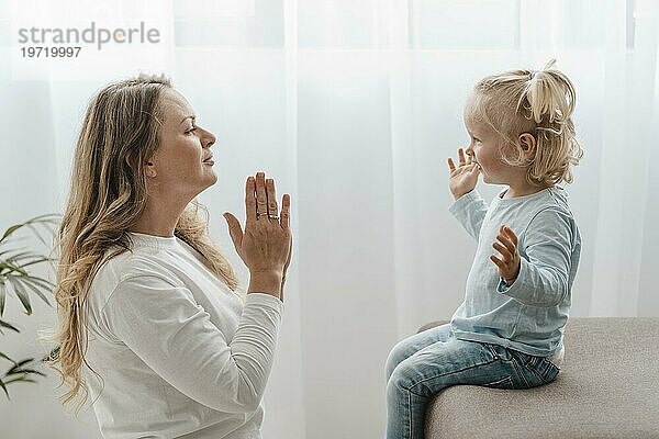 Seitenansicht Mutter betet mit ihrem Kind zu Hause