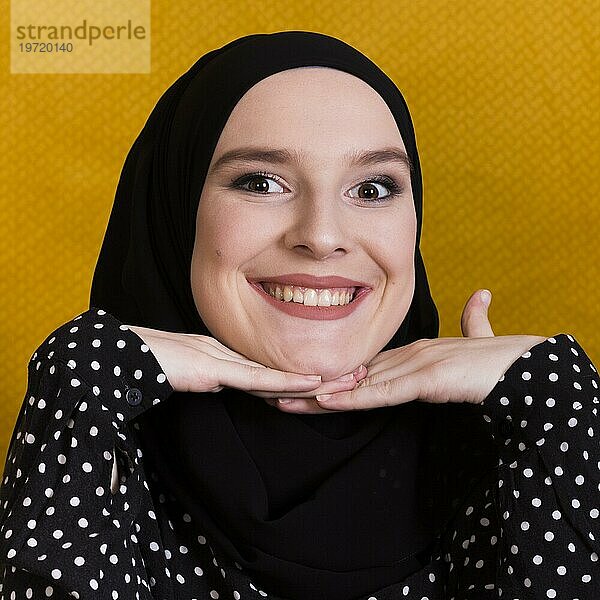 Hübsche lächelnde islamische Frau schaut in die Kamera