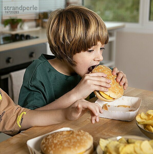 Kind ißt Burger zu Hause