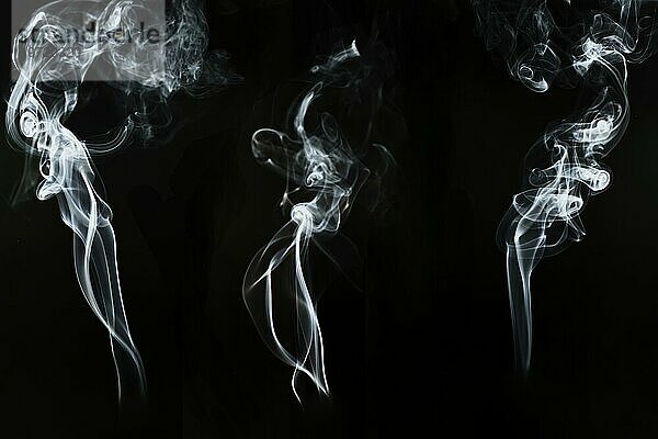 Drei große Silhouetten weißer Rauch