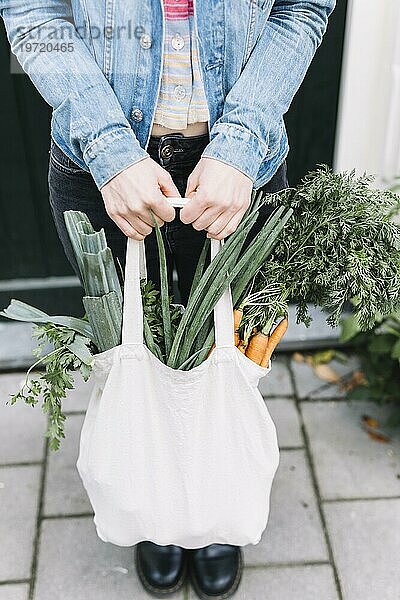 Close up Frau s Hand hält Baumwolltasche mit Gemüse