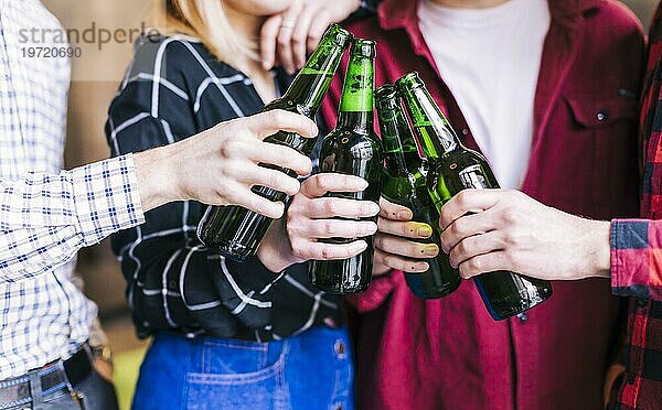 Gruppe Freunde stößt mit Flaschen Bier an