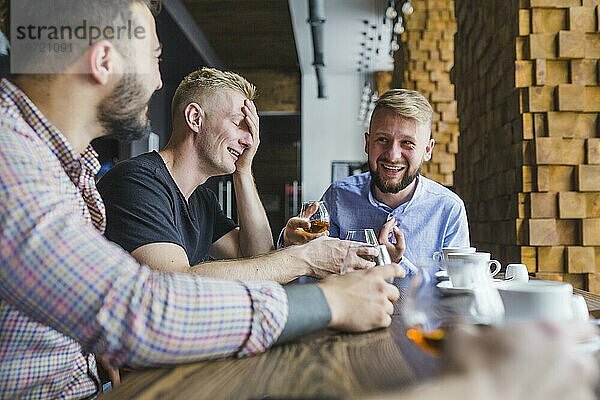 Männliche Freunde bei abendlichen Getränken im Restaurant