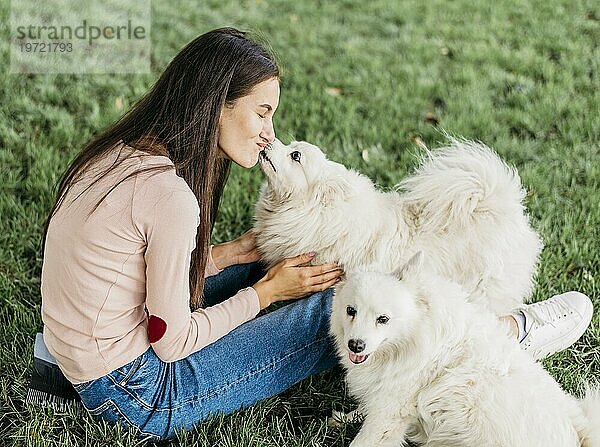 Frau glücklich spielen mit niedlichen Hunden