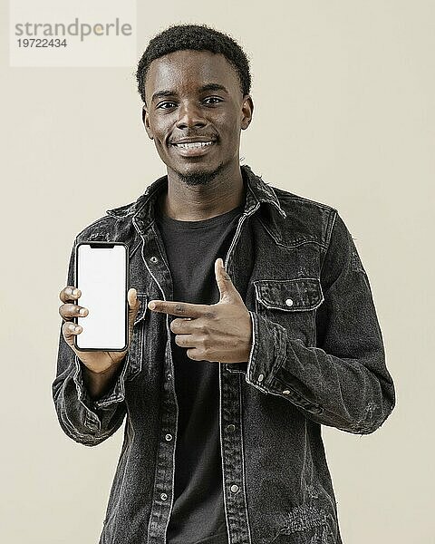 Porträt junger hübscher Mann posiert mit Handy