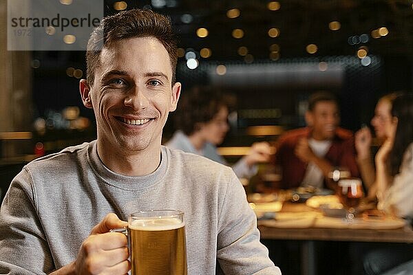 Nahaufnahme eines lächelnden Mannes mit Bierkrug