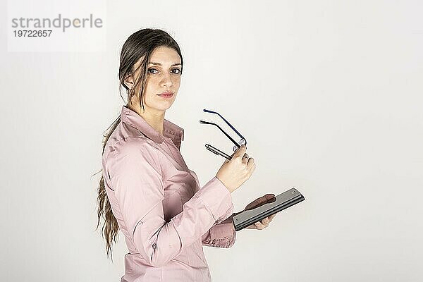 Studioporträt einer jungen blonden Geschäftsfrau mit Tablet und Brille. Weißer Hintergrund. Kopierraum