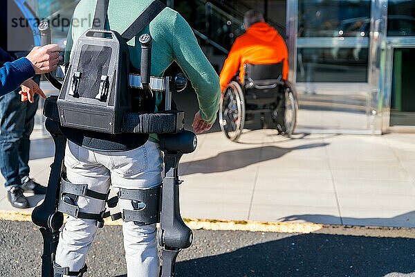 Mechanisches Exoskelett  behinderte Person  die mit Hilfe des Roboterskeletts den Behandlungsraum betritt  Physiotherapie in einem modernen Krankenhaus  futuristische Physiotherapie