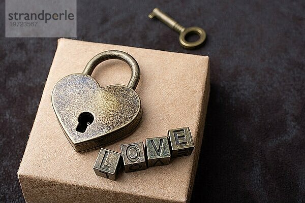 Vorhängeschloss in Form einer Liebe  Schlüssel und Aufschrift Liebe auf der Schachtel
