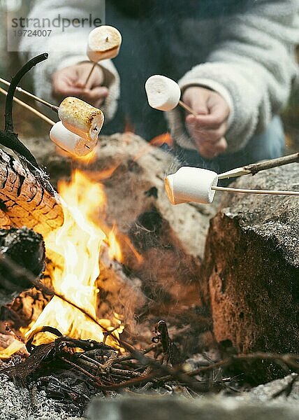 Junge Frau brennt Marshmallows am Lagerfeuer