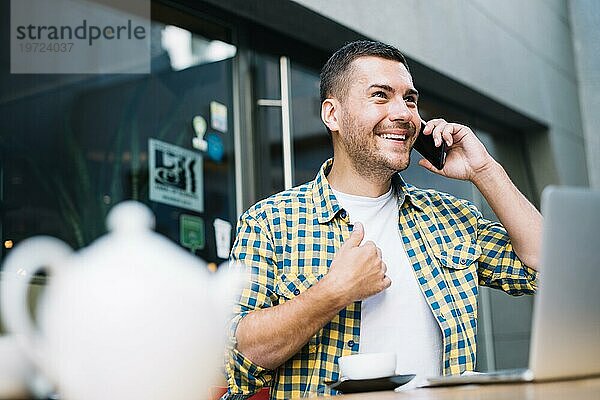 Mann emotional sprechendes Telefoncafé