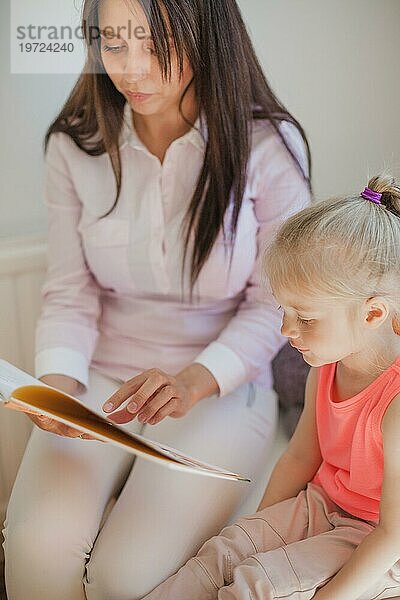 Frau und Mädchen lesen gemeinsam ein Buch