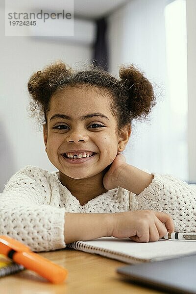 Frontansicht glückliches kleines Mädchen zu Hause während der Onlineschule mit Laptop