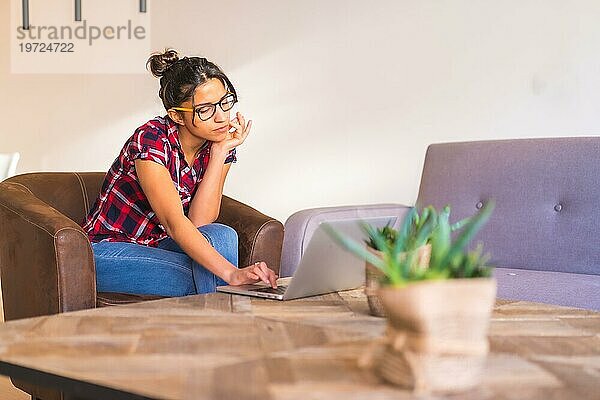 Fokus auf eine junge Geschäftsfrau  die von zu Hause aus mit einem Laptop arbeitet
