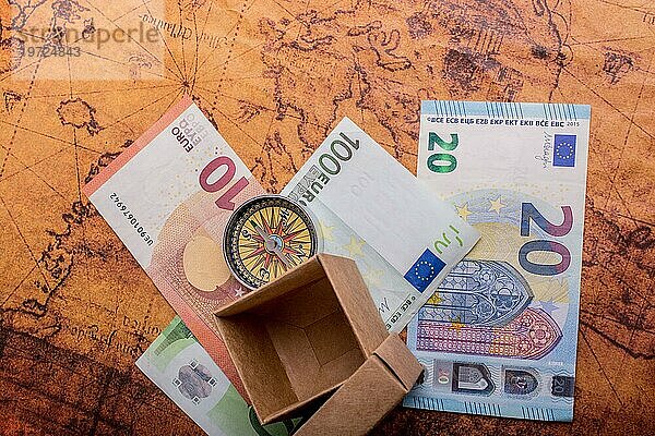 Kompass  Schachtel und Eurobanknoten auf Landkarte als Geschäftskonzept