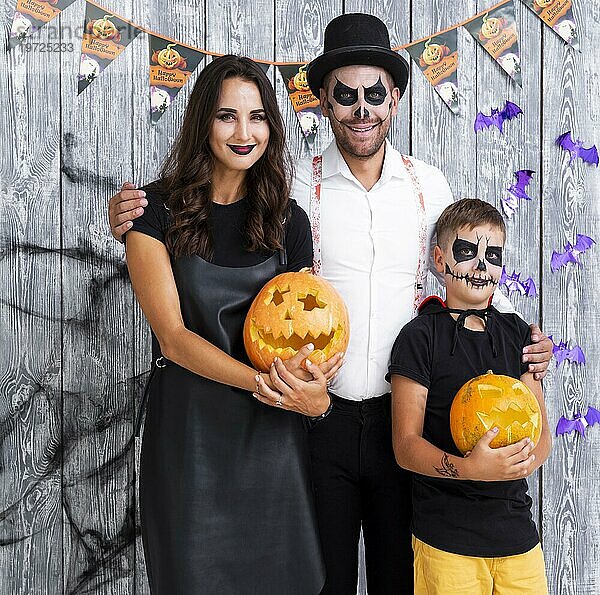 Glückliche Eltern mit Sohn posieren zu Halloween