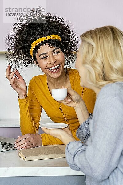 Zwei Frauen lachen beim Kaffee trinken
