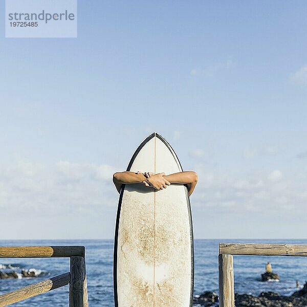 Frau mit Surfbrett am Strand