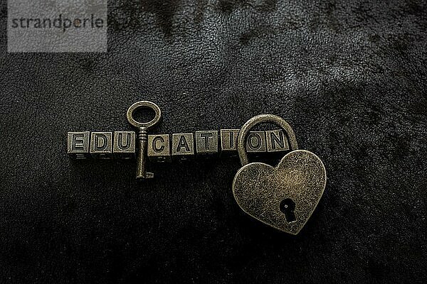 Liebe geformt Vorhängeschloss  Schlüssel und Bildung Wortlaut auf dunklem Hintergrund